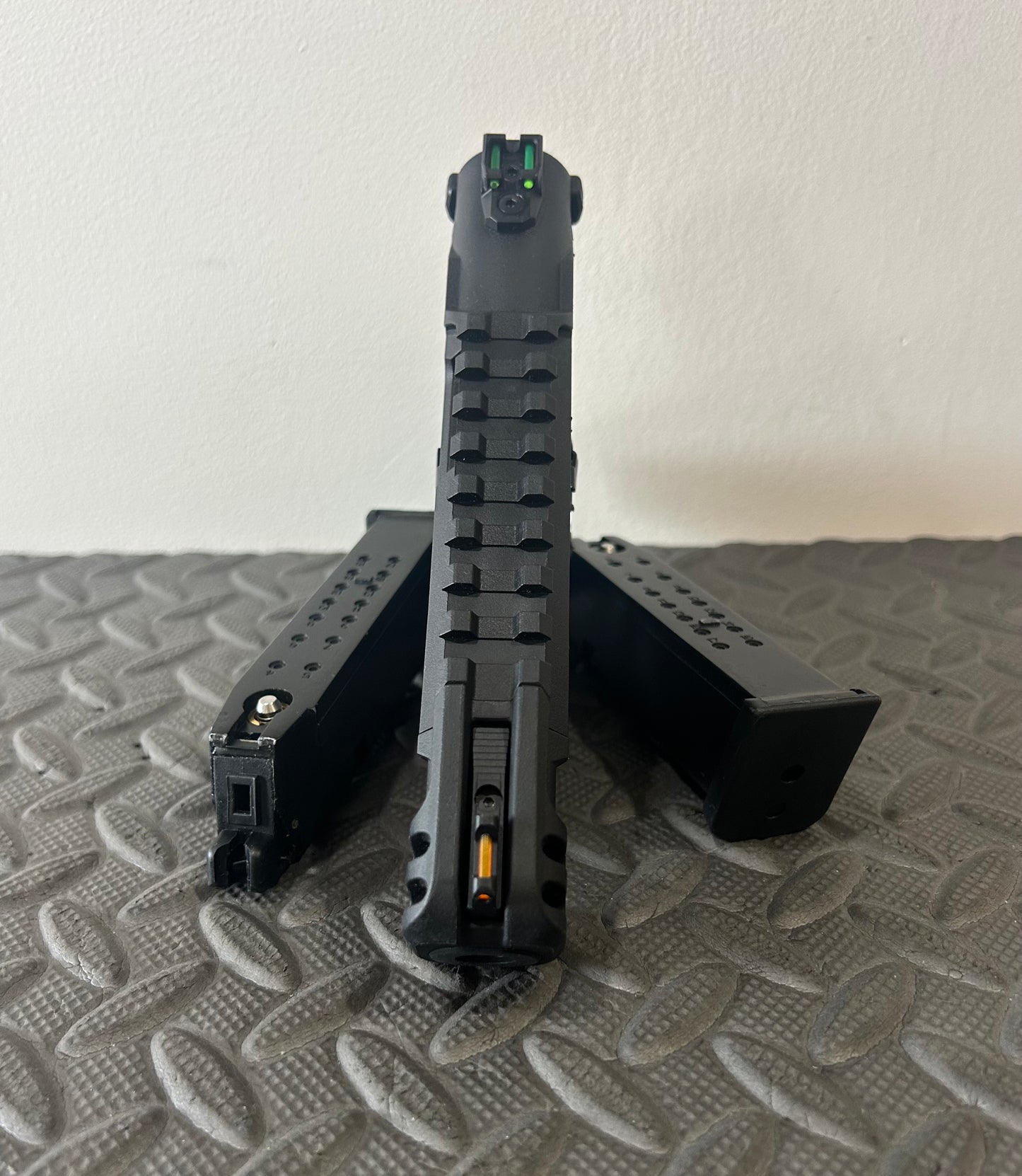 Front view of ACTION ARMY aap-01c assasin airsoft pistol with two magazines on textured surface