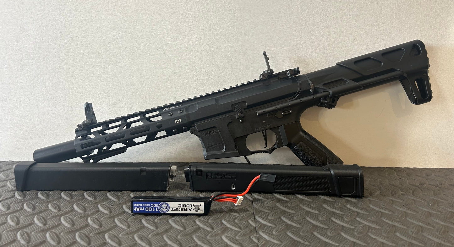 G&G AEG arp9 airsoft gun with black finish and extended handguard displayed with battery and charger