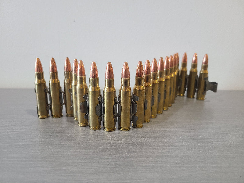 DISTRICT AIRSOFT bullet belt with copper-tipped rounds arranged on gray surface