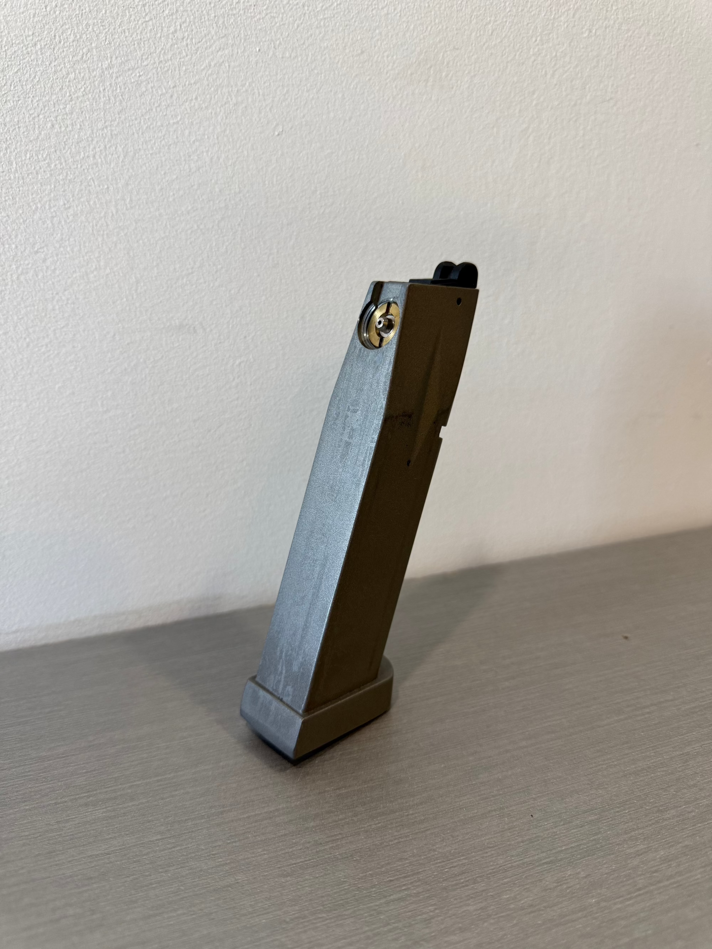 used KWC P226 X-5 CO2 magazine standing upright on a gray surface showing base plate and feed lips