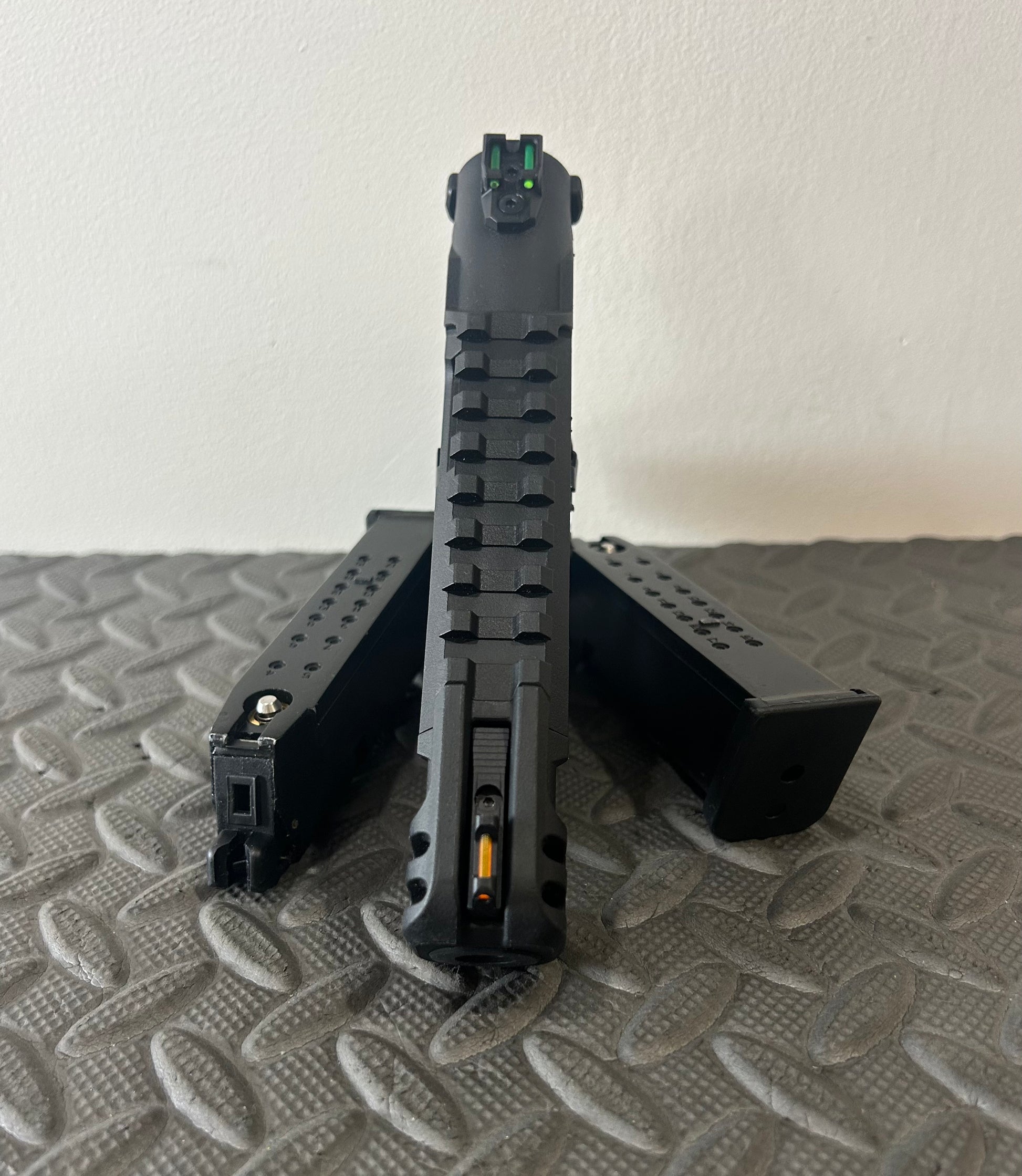 Front view of ACTION ARMY aap-01c assasin airsoft pistol with two magazines on textured surface
