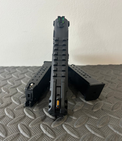 Front view of ACTION ARMY aap-01c assasin airsoft pistol with two magazines on textured surface