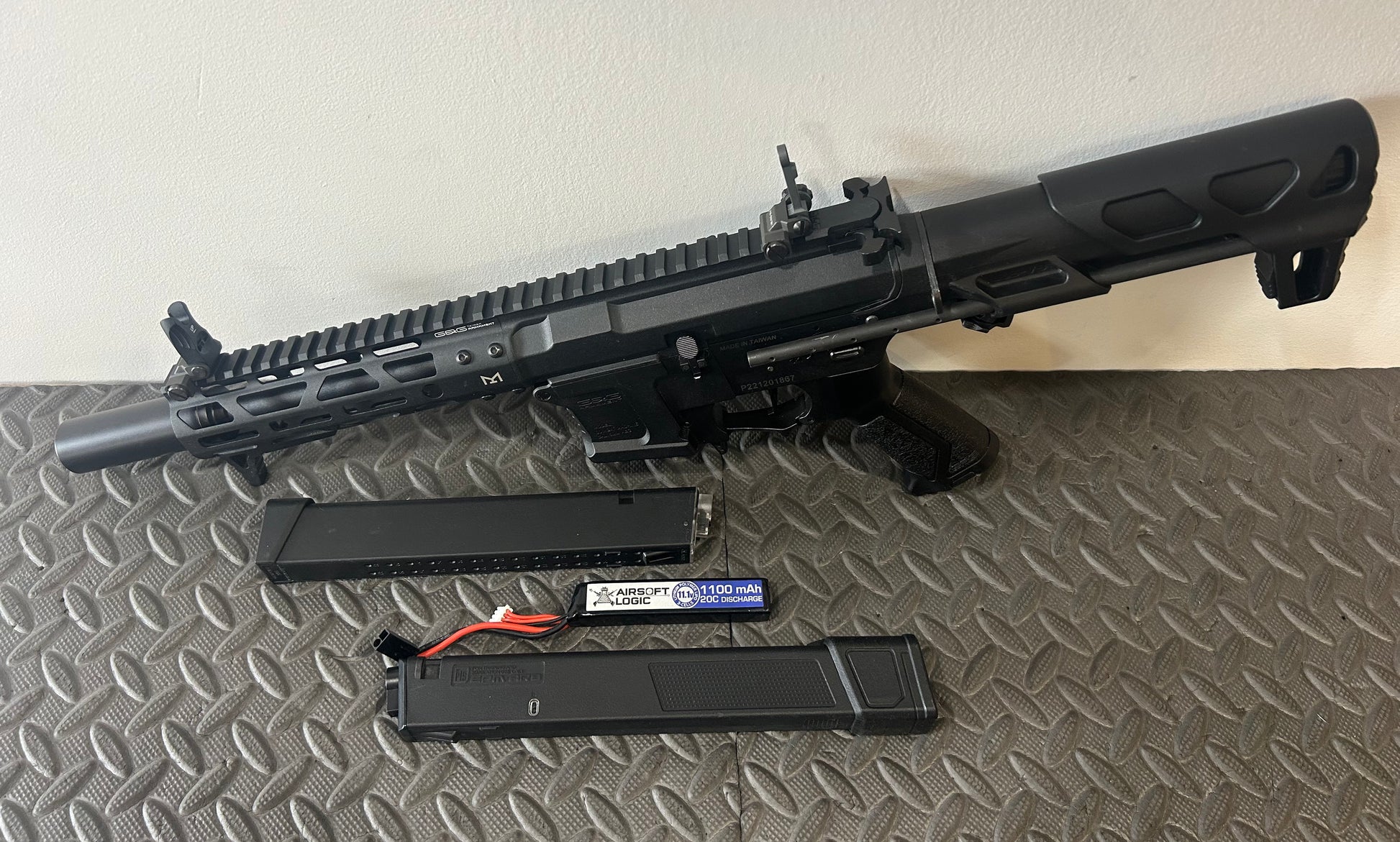 G&G AEG arp9 airsoft gun with two magazines and a rechargeable battery on a textured surface