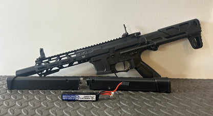 G&G AEG arp9 airsoft gun with black finish and extended handguard displayed with battery and charger