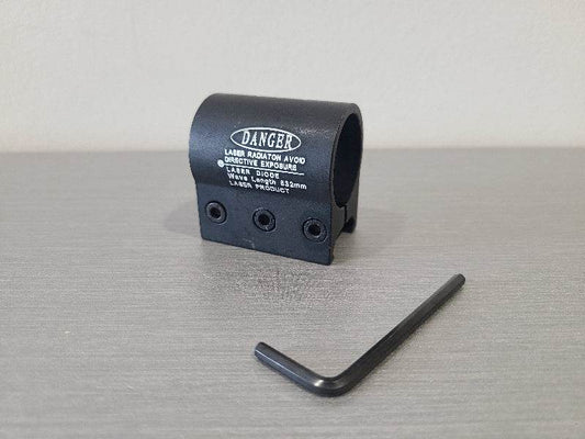 Black flashlight h9 ring accessory with warning label and included hex key tool on gray surface