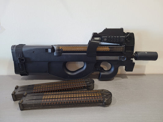 Fusil AEG G&G PDW99 noir avec deux chargeurs transparents posés sur une surface claire