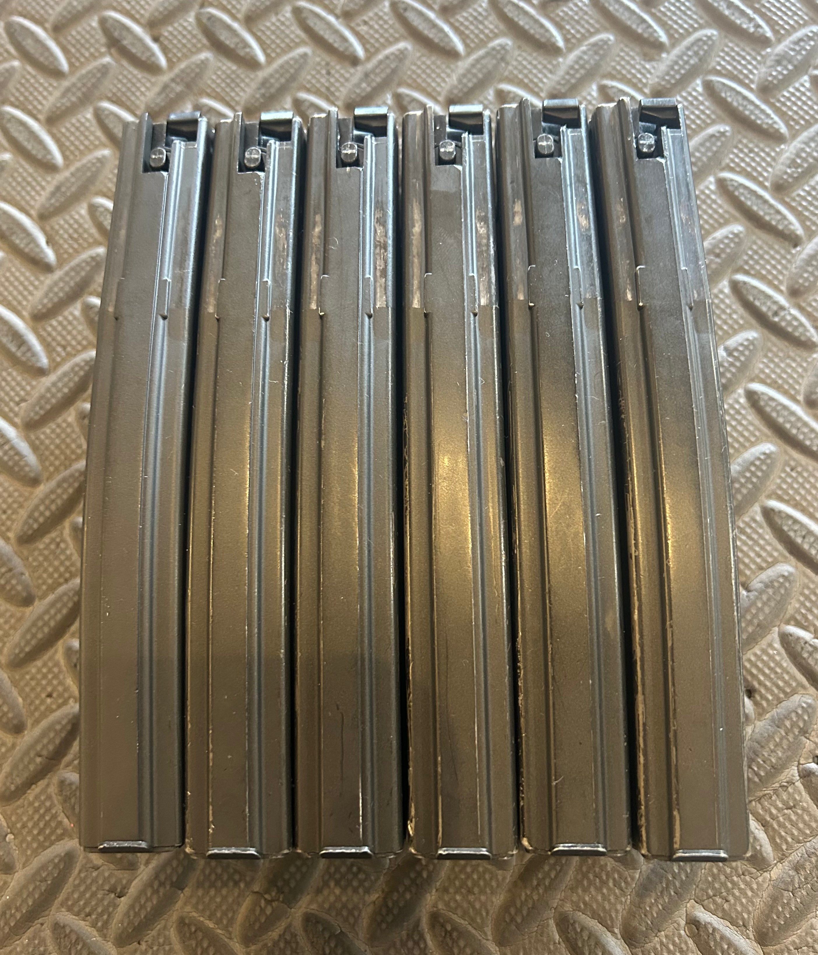 Set of seven Tokyo Marui M4 MWS GBBR magazines stacked together for airsoft enthusiasts